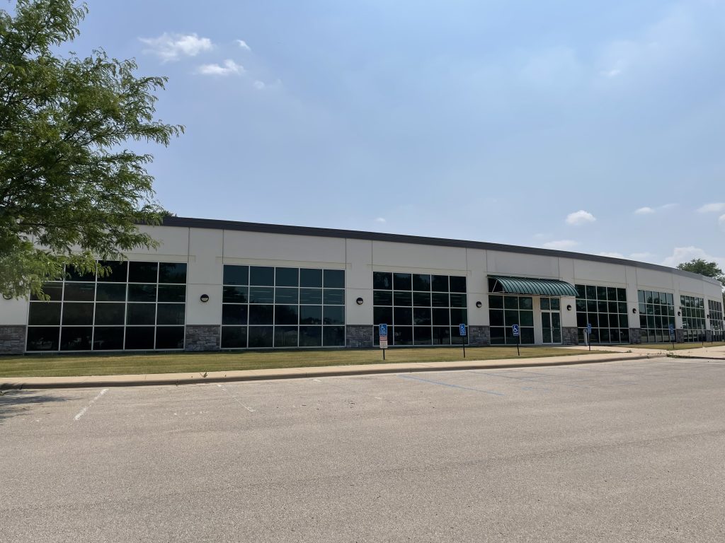Landscape photo of Cedar Rapids Headquarters and parking lot with blue sky.