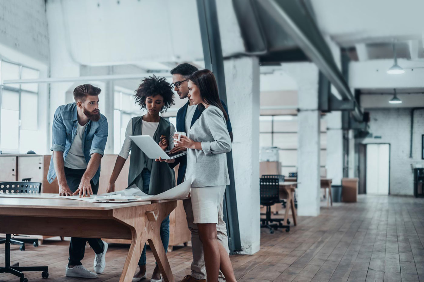 A business team works in a nice office going over reports on a computer