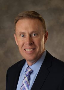 Headshot of Dusky Terry on brown background.