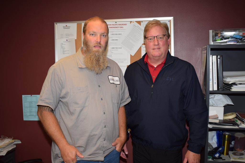 Two men side by side smiling.