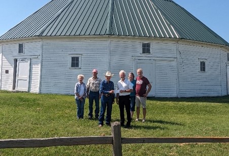 Group of people standing in front of white barn
