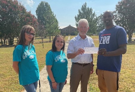 Three people holding a check: Amanda Wilson, Randi Mitchell, Kim Goodnight, and Chris Scott