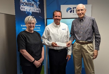 ITC Manager J.R. Behan presents a check to President Raymond Powers, with Treasurer Mary Galligan