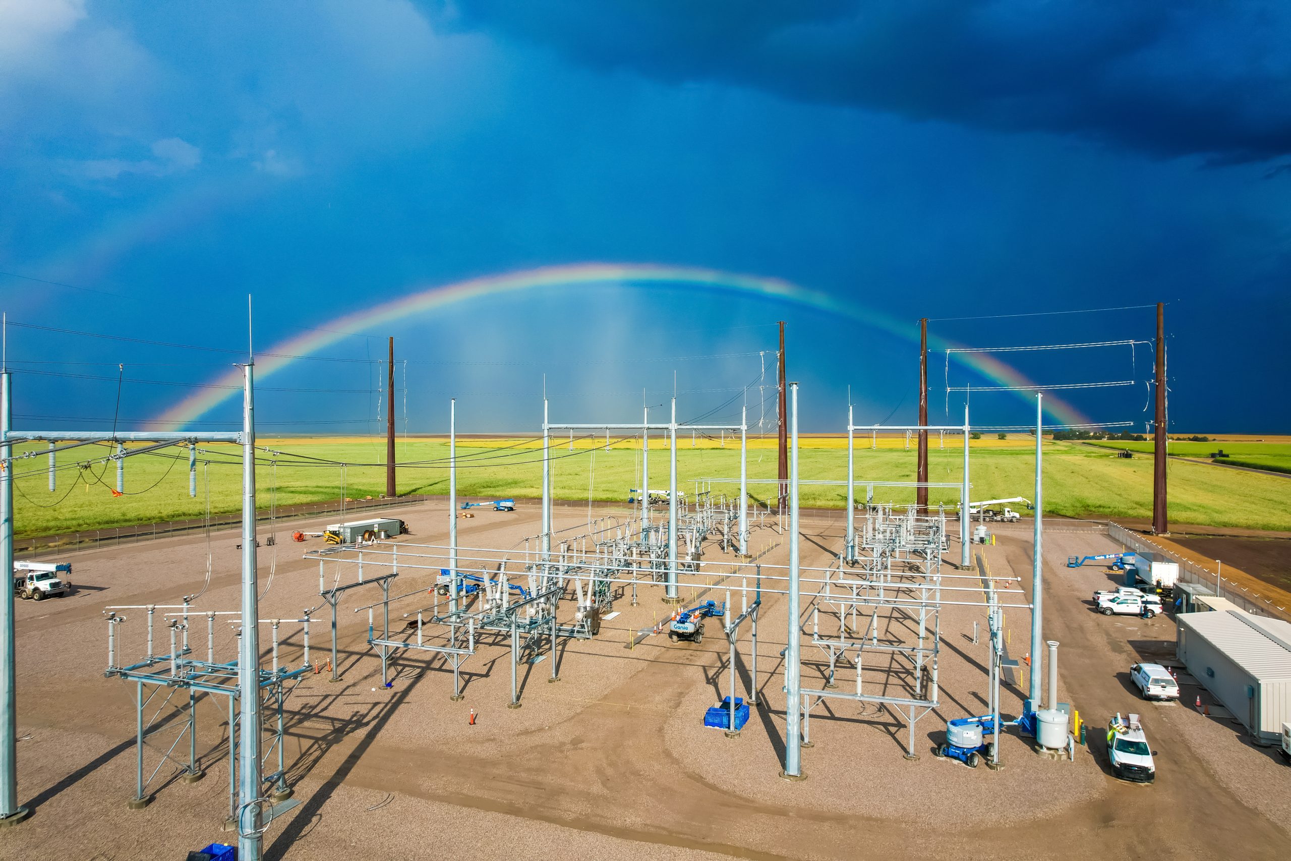 Dark blue sky with rainbow over transmission station