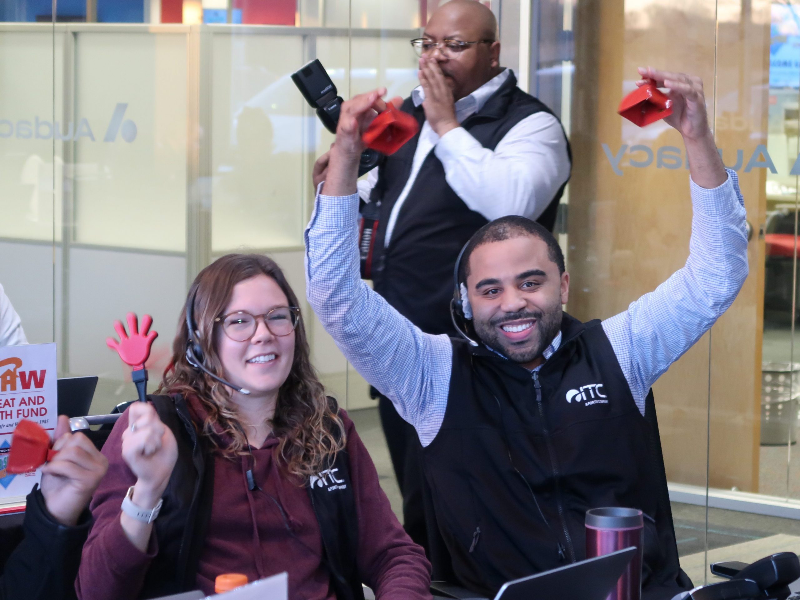 Team at table with laptops and phones, collaborating on projects