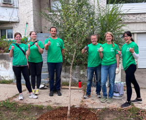 Group of volunteers in green shirts planting trees in Grand Rapids MI.