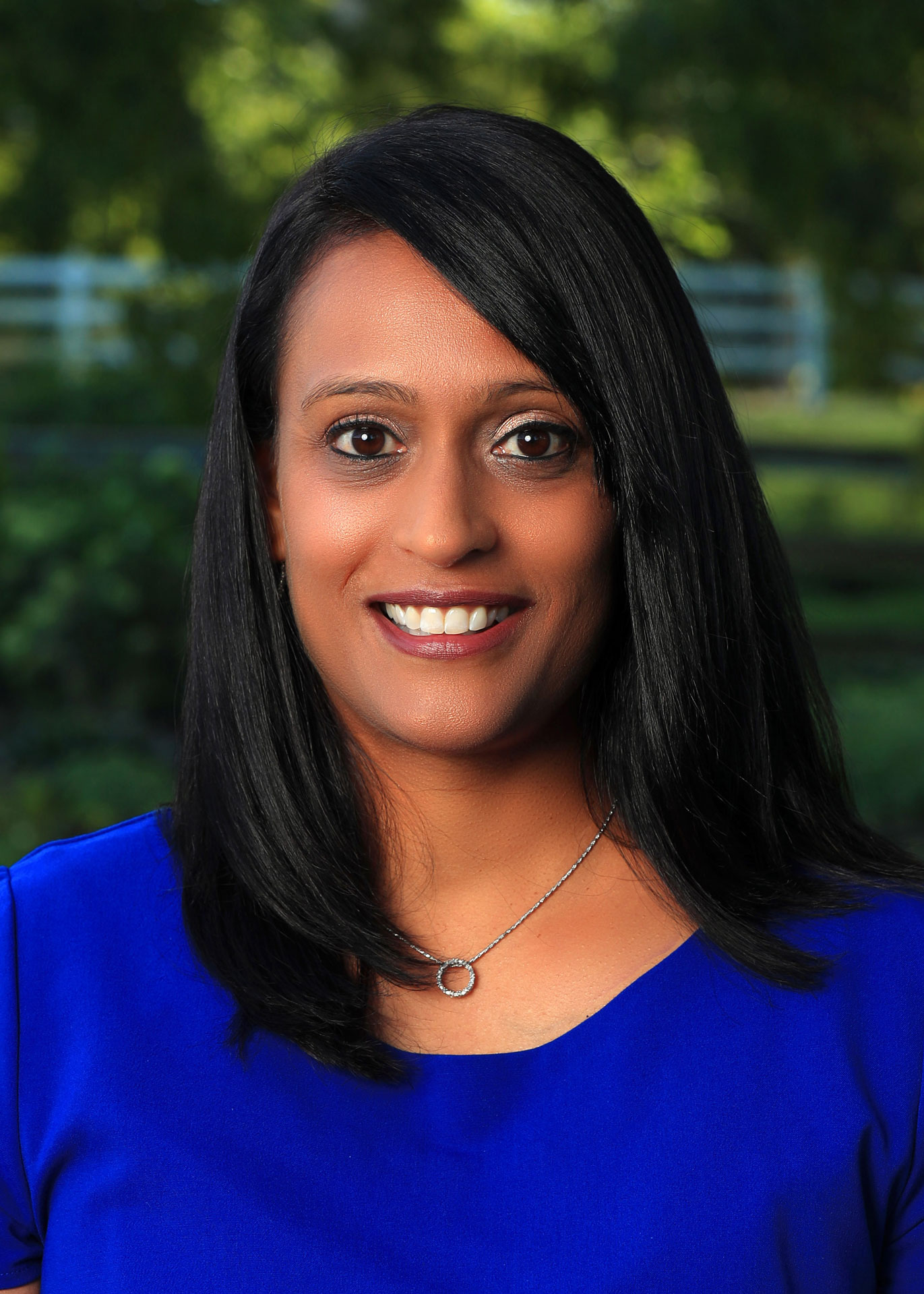 Headshot of Purvi Patel in front of greenery.