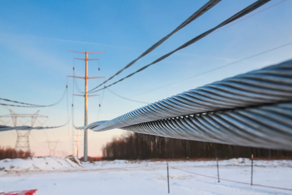 Close up of transmission conductors in a snowy field.