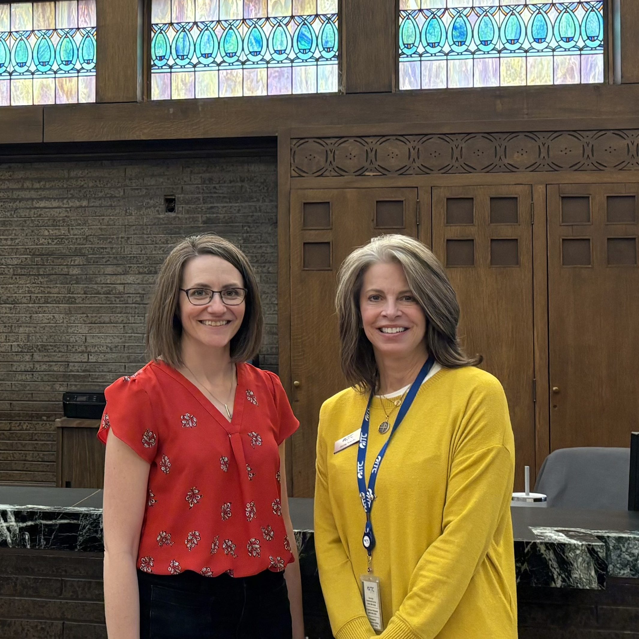 Two people standing side by side in a local business.