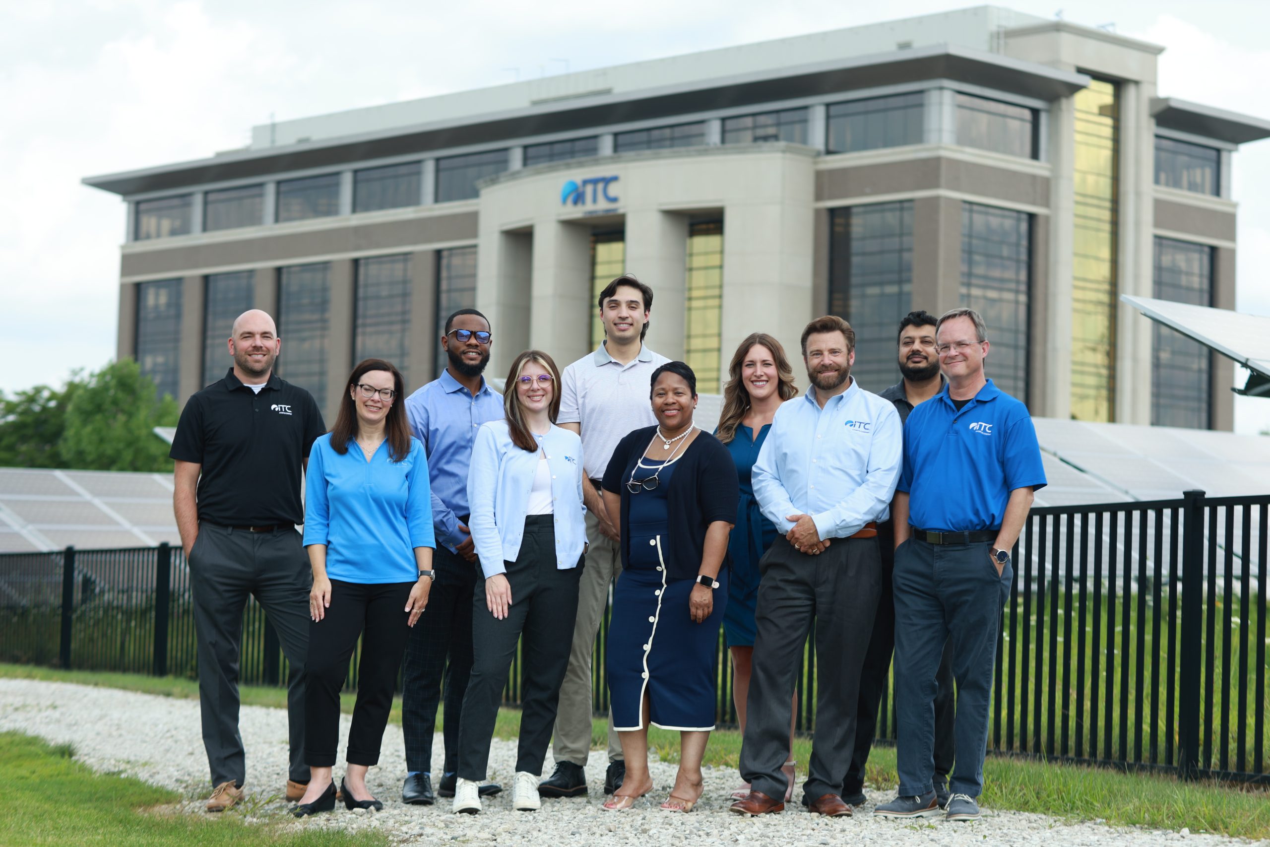 Group of ITC employees posed for photo outside headquarters building.