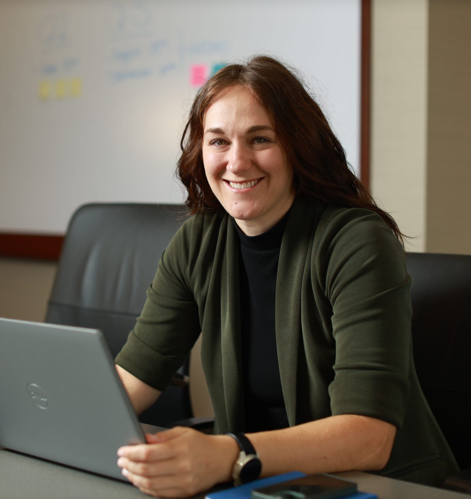Person at a computer with whiteboard behind them in a conference room.