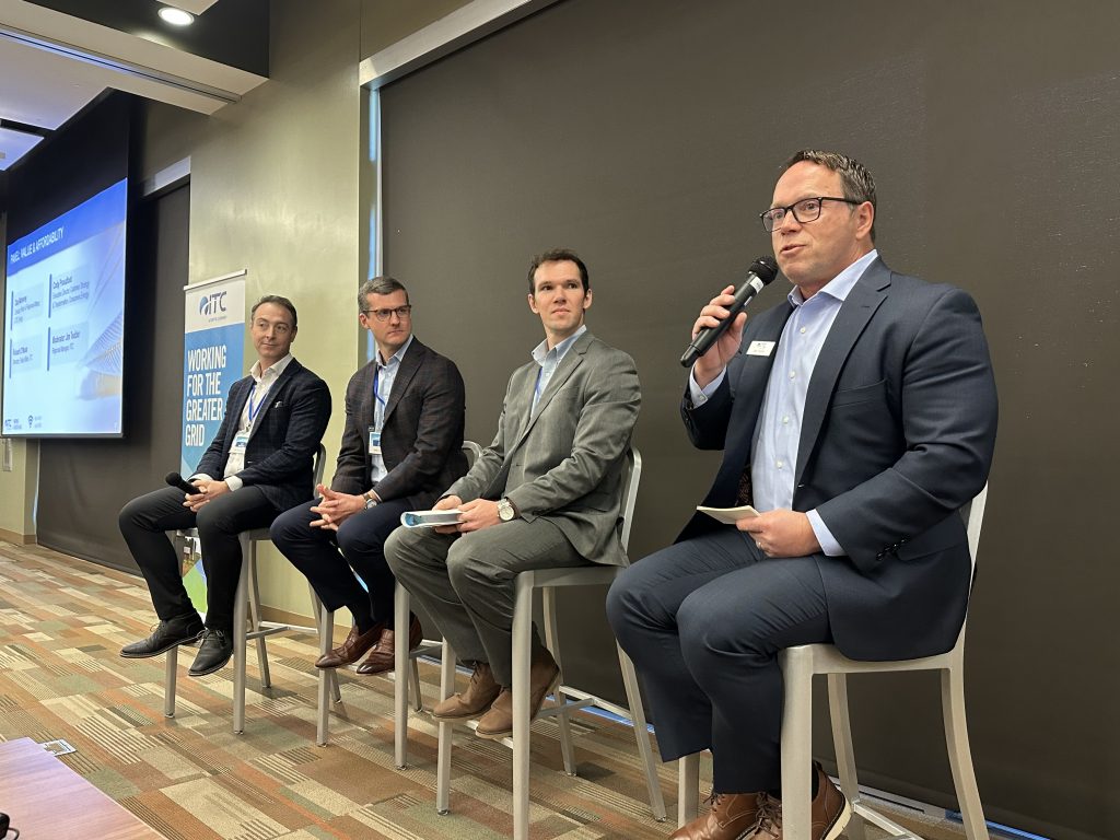 Group of people on stage at Michigan Partners in Business meeting to discuss updates.
