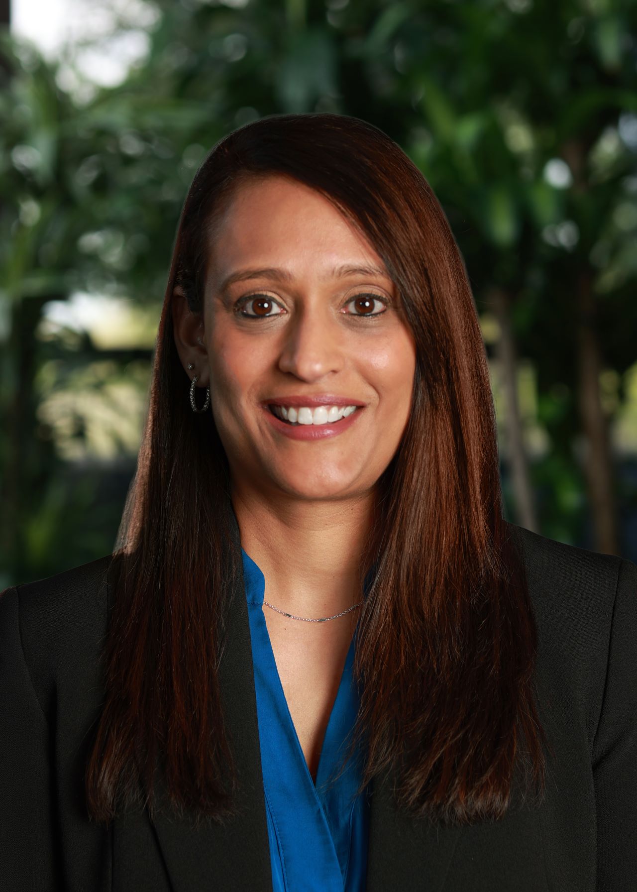 Headshot of Purvi Patel on greenery background.